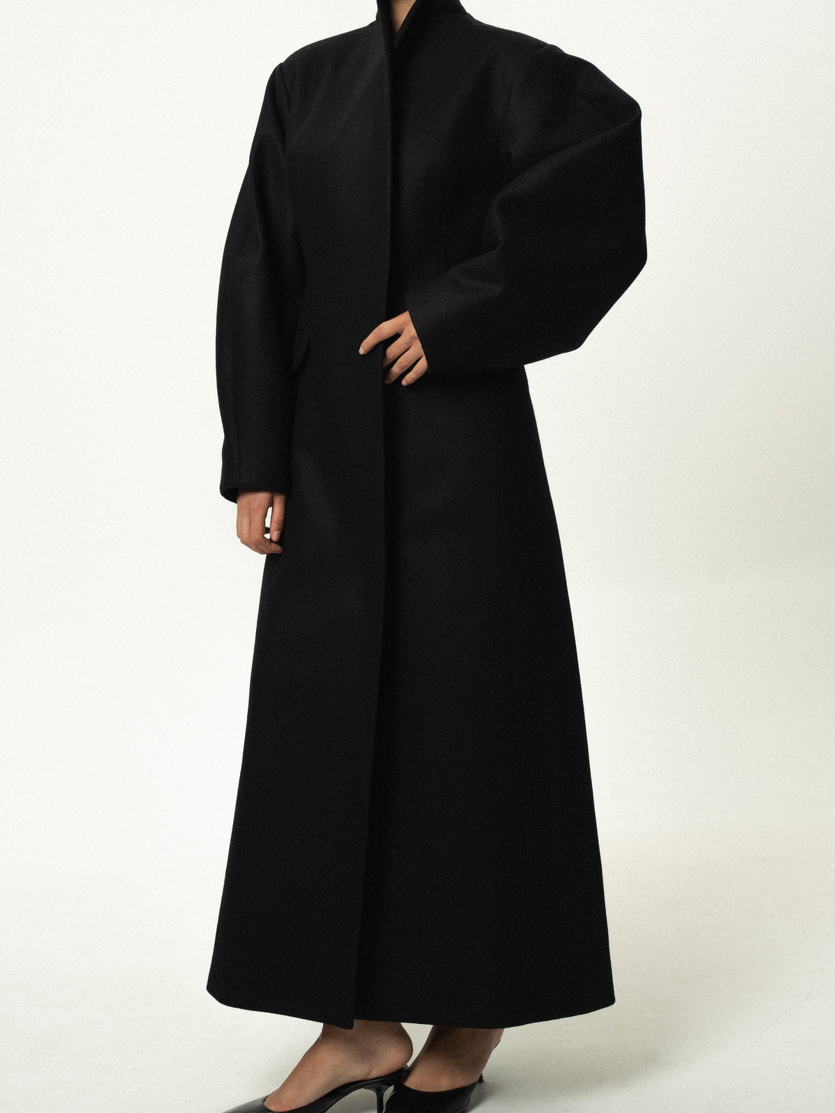 Fitted balloon-sleeve wool coat in black, three-quarter view