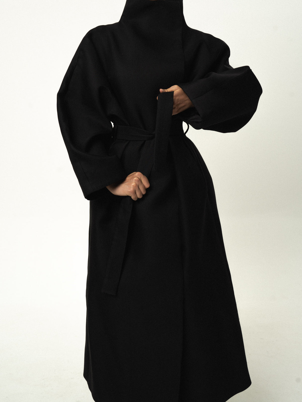 Belted cotton-silk trench coat in black, tying the belt