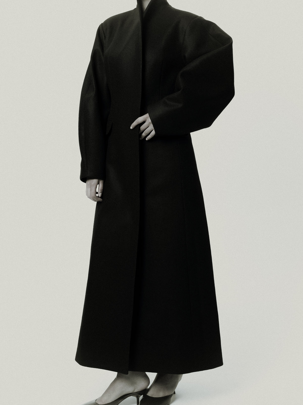 Fitted balloon-sleeve wool coat in black, three-quarter view