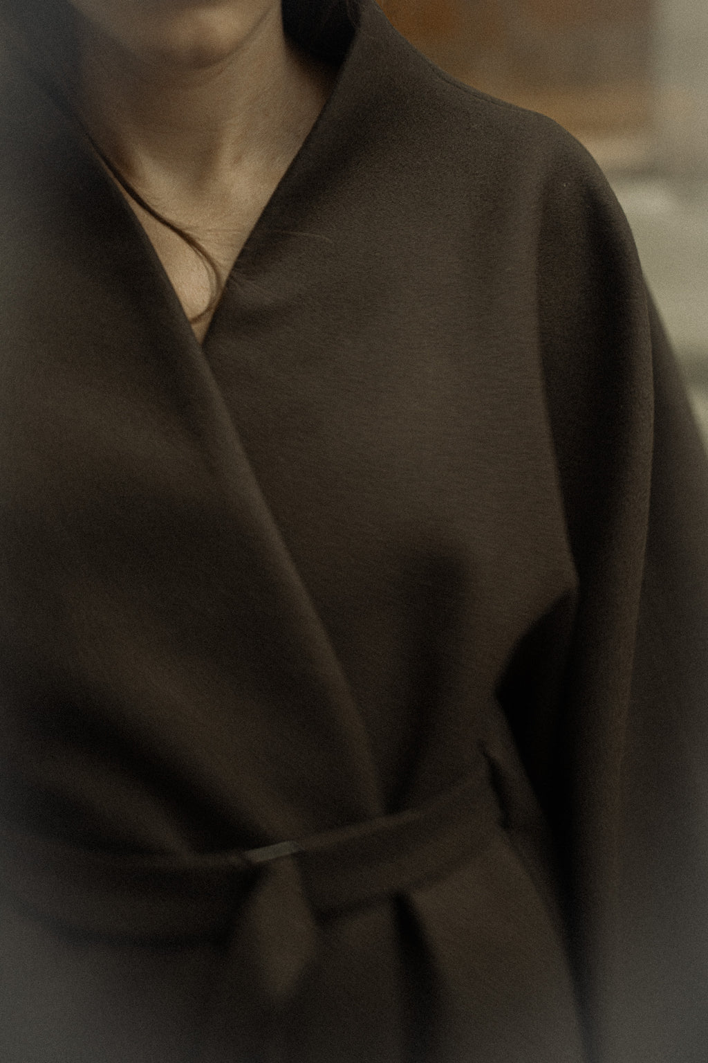 Kimono convertible en laine, teinte mousse, gros plan sur l'encolure croisée et la ceinture